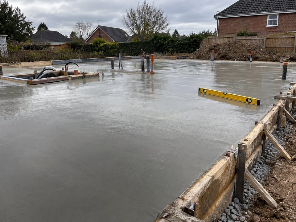 A freshly poured concrete slab with a spirit level on it, stamped 10:40, Tuesday 1 September 2026, Tom Reilly