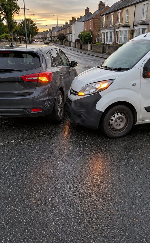 Foto berstempel hatchback abu-abu dan van putih setelah tabrakan ringan di jalan permukiman, di penampil foto PicAnchor